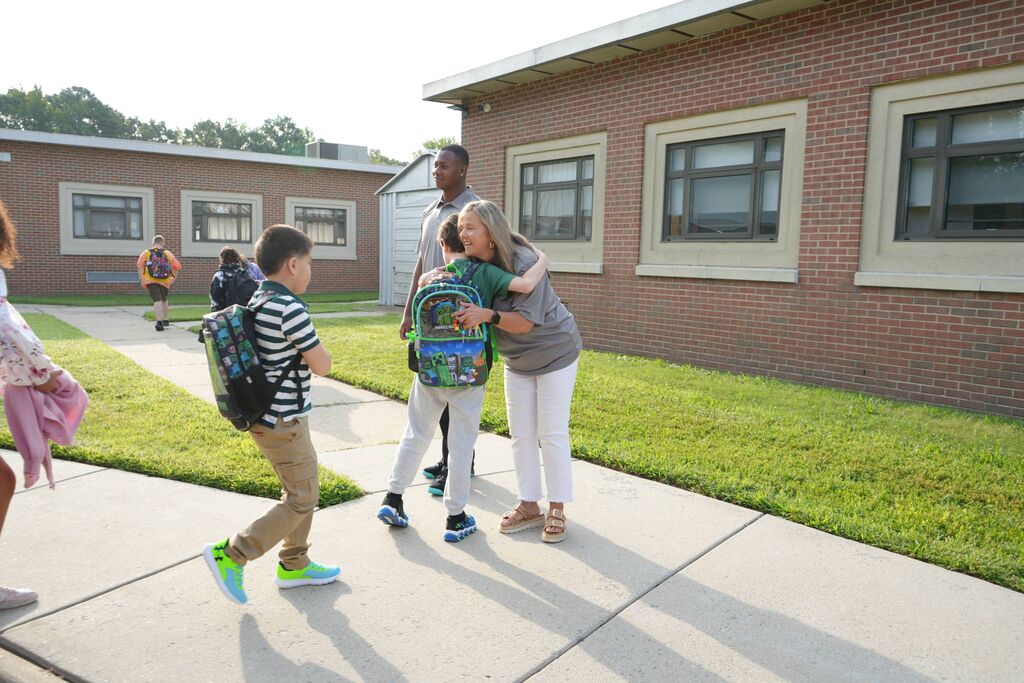 teacher hugging student outside of school