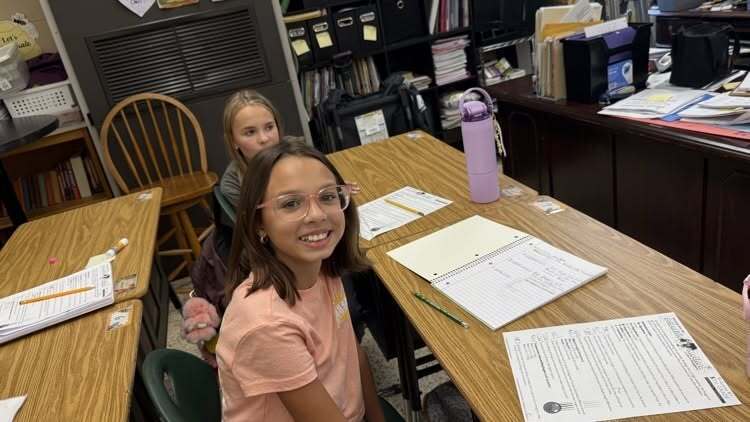 2 Girls Smiling with work at desks