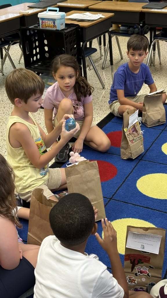 Students sitting in circle sharing about me items