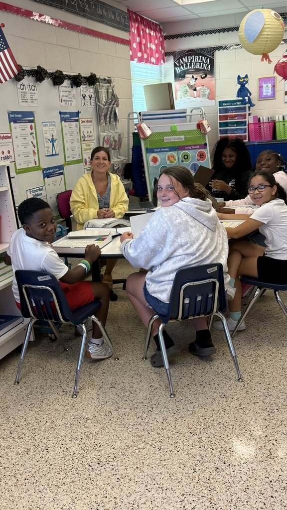 Students working at small table with teacher