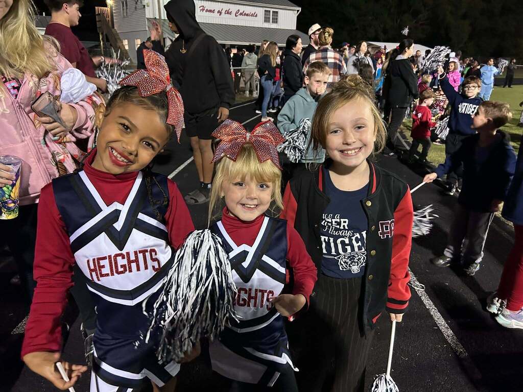 Group shot of 3 elementary girls dressed in colonial heights cheerleader gear