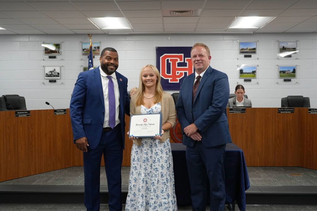 Superintendent, August Senior of the Month, and Board Chair in a group picture. student has certificate of achievement