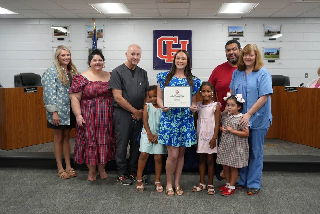 September Senior of the Month holding her certificate in a group photo with her family