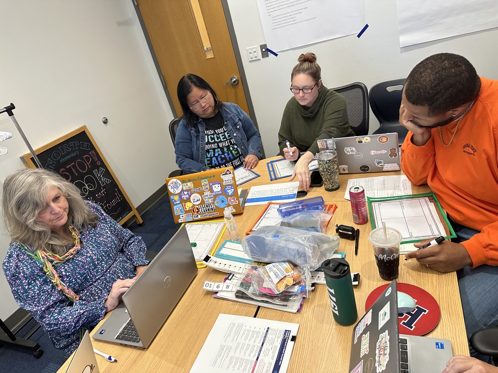 Teachers collaboarting at table with their laptops and math manipulatives