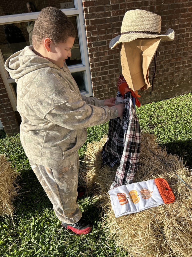 Boy dressing scarecrow