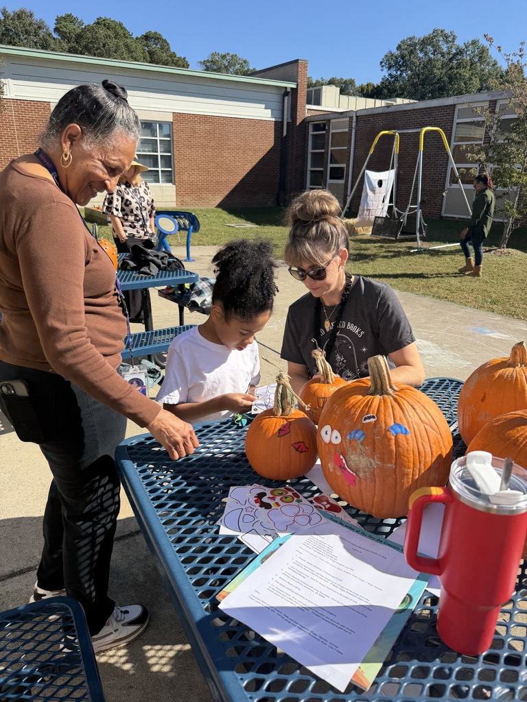 Boy Decorating Pumpkin with Stickers with 2 teachers