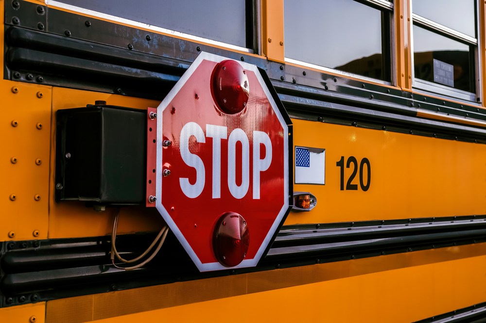 close up of a stop sign on the side of a school bus