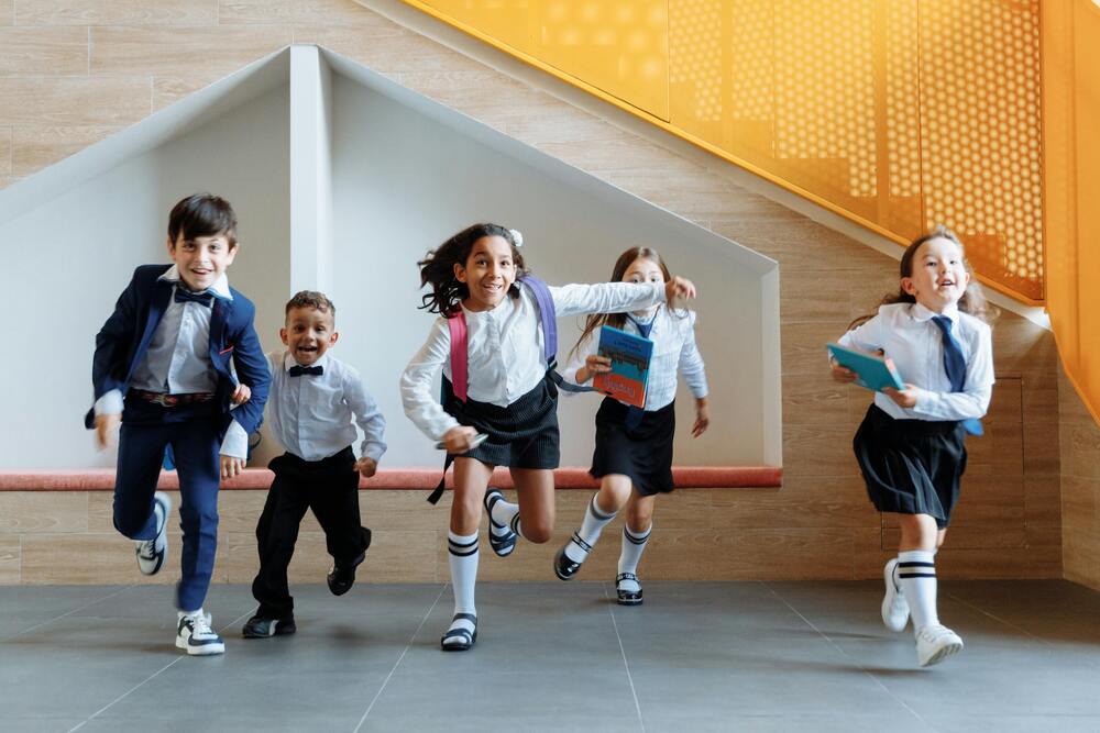 students in school uniforms running