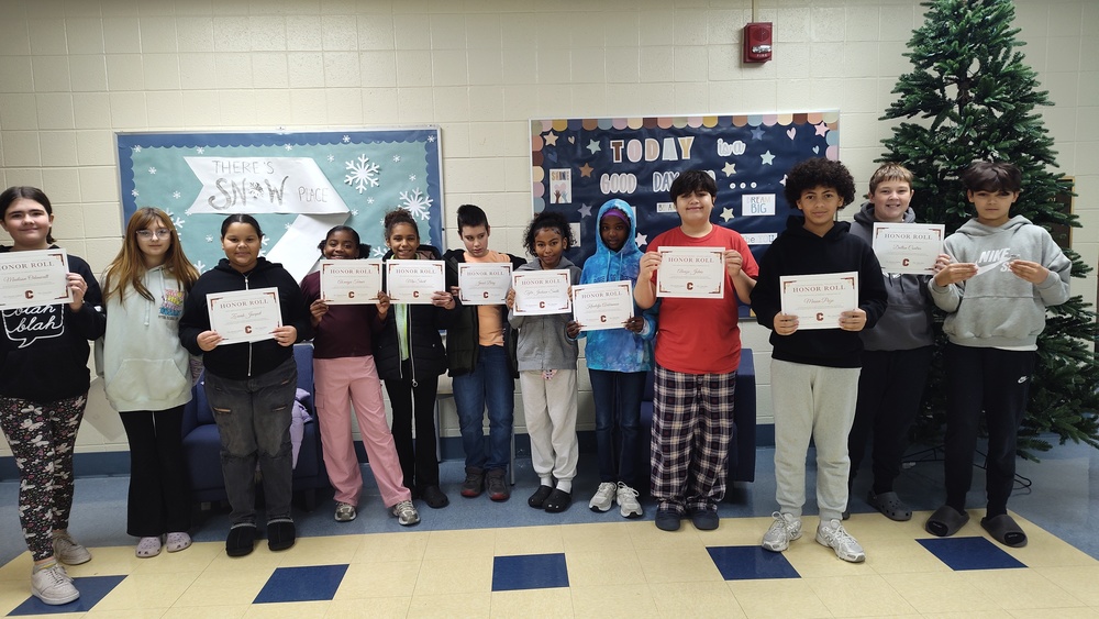 a homeroom of students holding their honor roll certificates