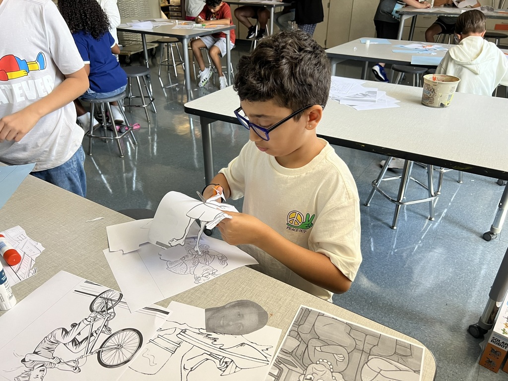 Student working on a classroom project – A CMS Taylor Middle School student cuts out paper shapes during a classroom art activity.