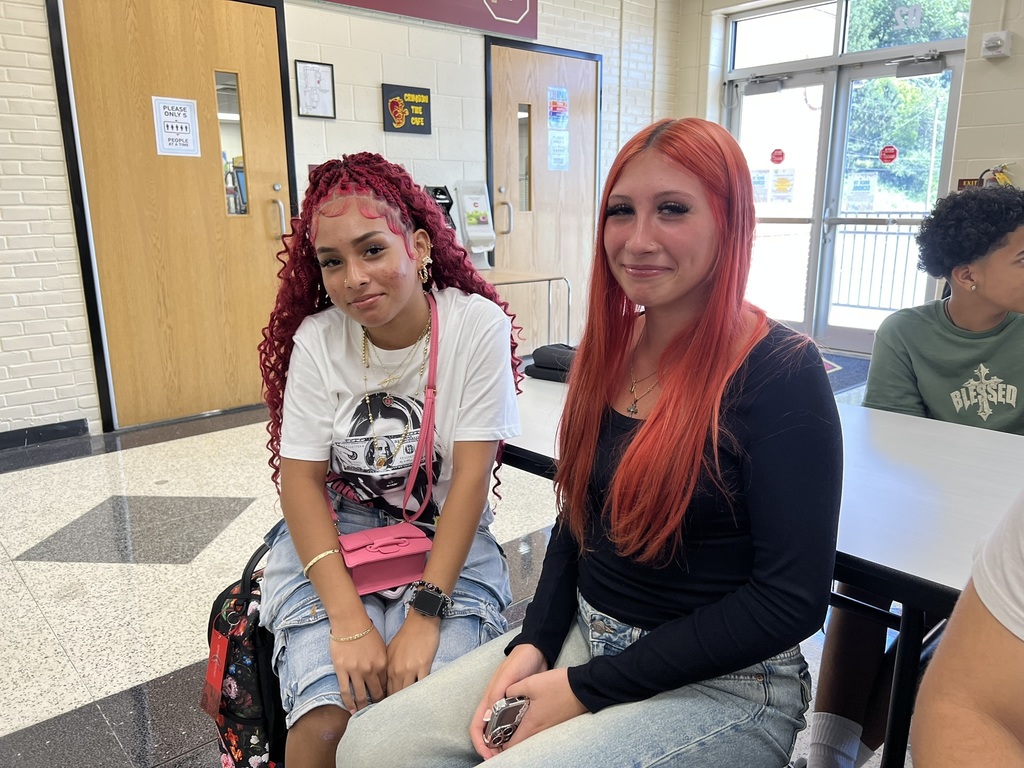 Two students sitting together – Two high school students sit at a cafeteria table, smiling for the camera on the first day of school.