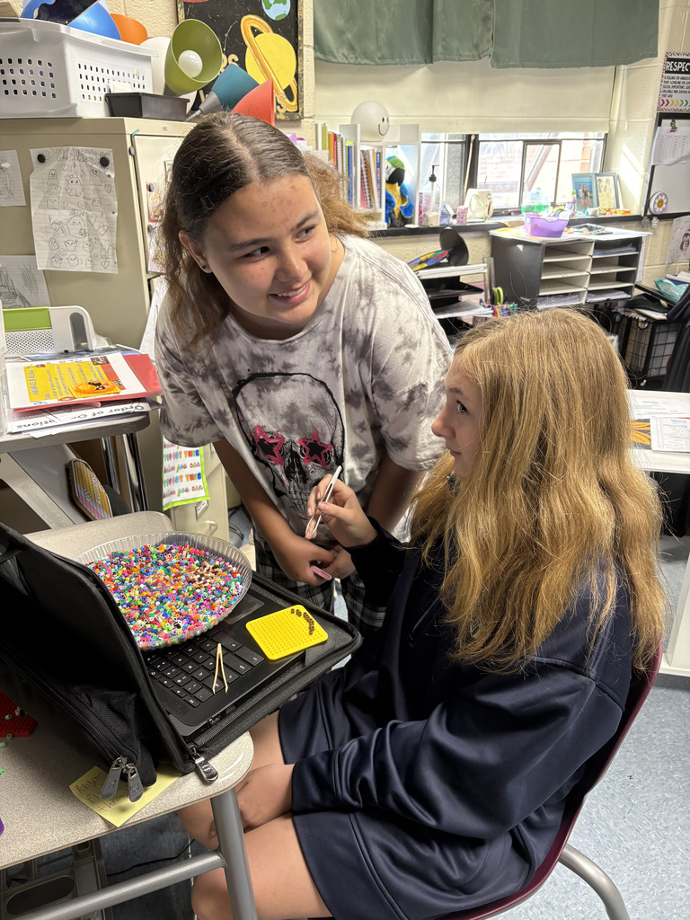 student sitting with a bowl of beads
