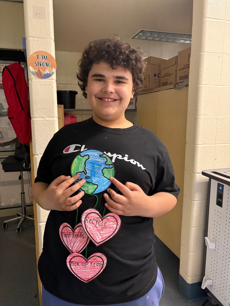 student holding an earth day project shaped like the earth