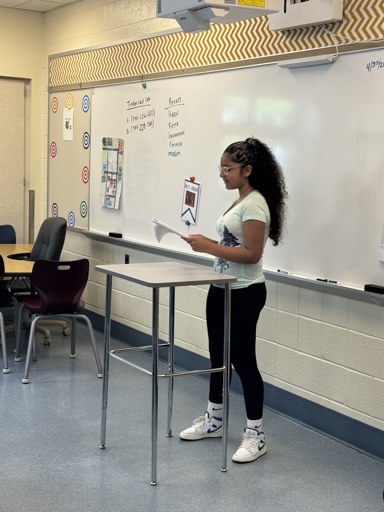 Student in front of a white board giving a speech