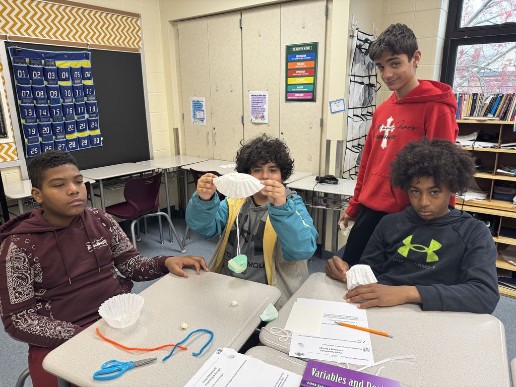 Students posing together with their peep and parachute