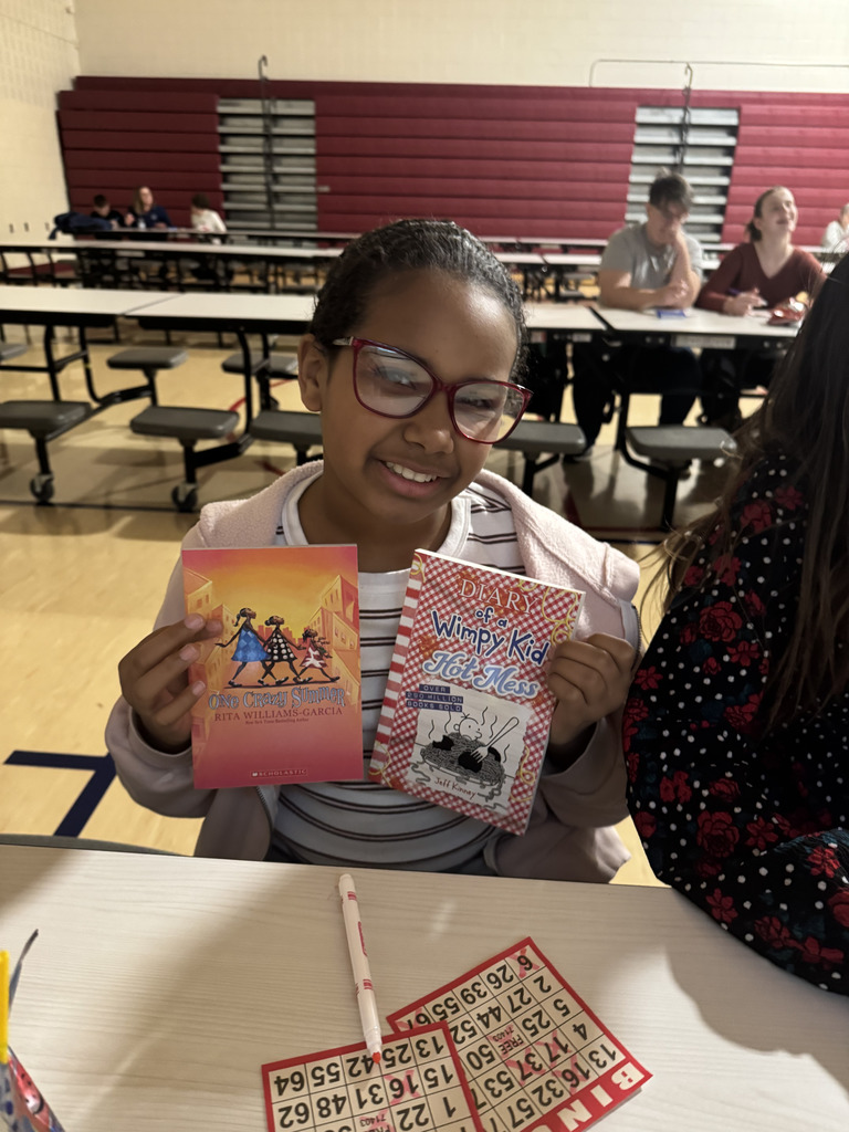 Girl holding books that they won during bingo