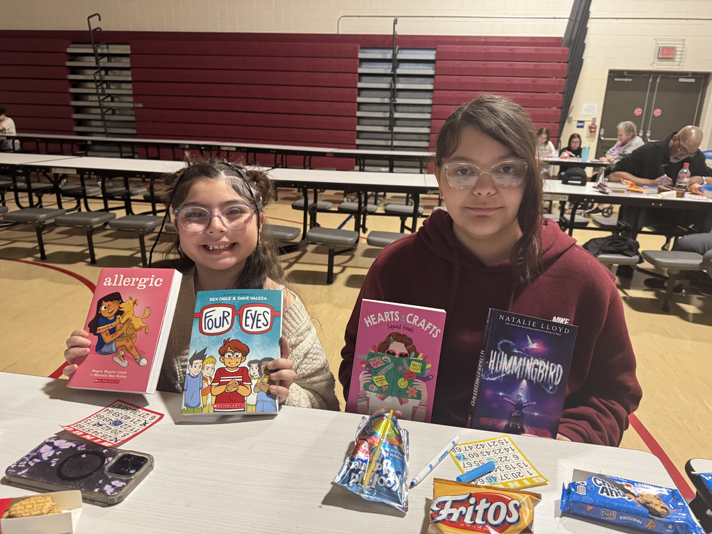 Girls holding books that they won during bingo