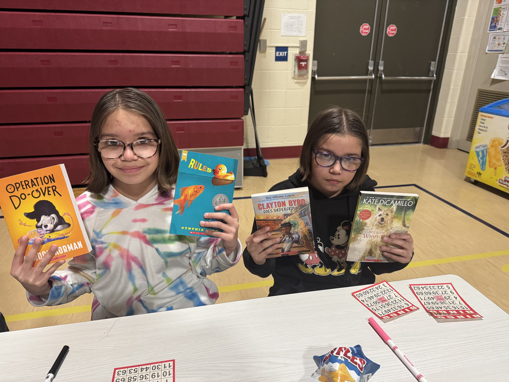 Girls holding books that they won during bingo