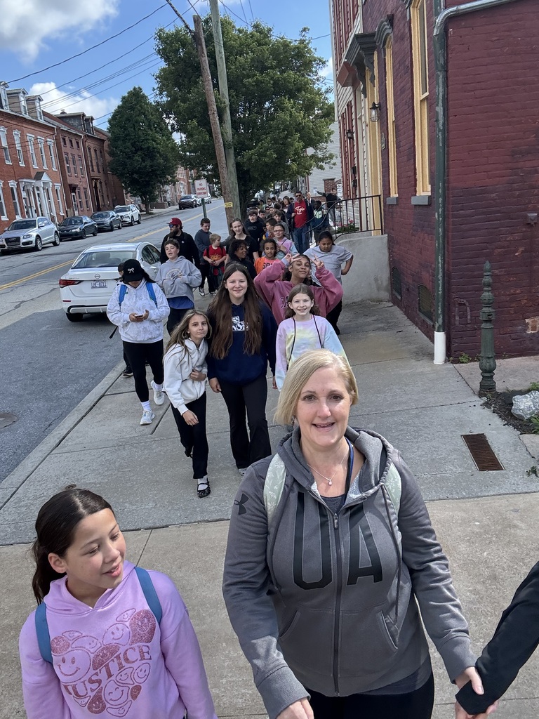 Several individuals gathered on a sidewalk, chatting and enjoying each other's company.