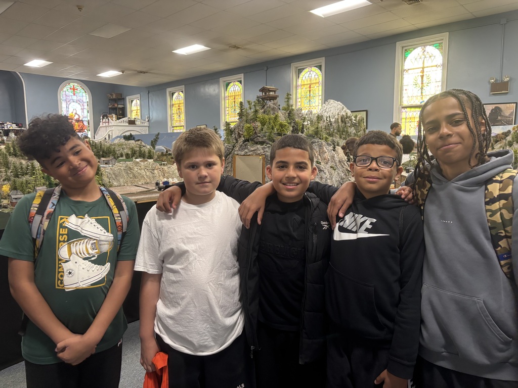  Four boys stand together for a photo outside a church, highlighting their friendship against the backdrop of the building.