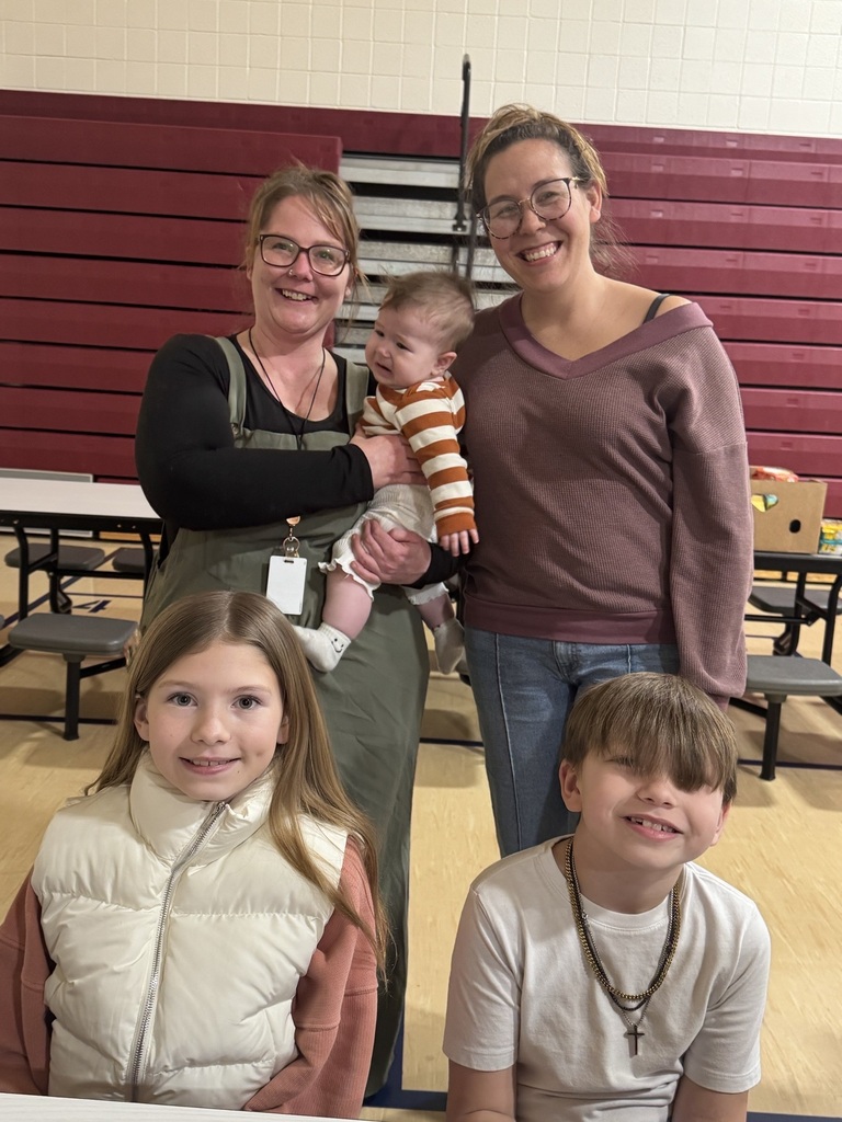 4 people and a baby standing and smiling