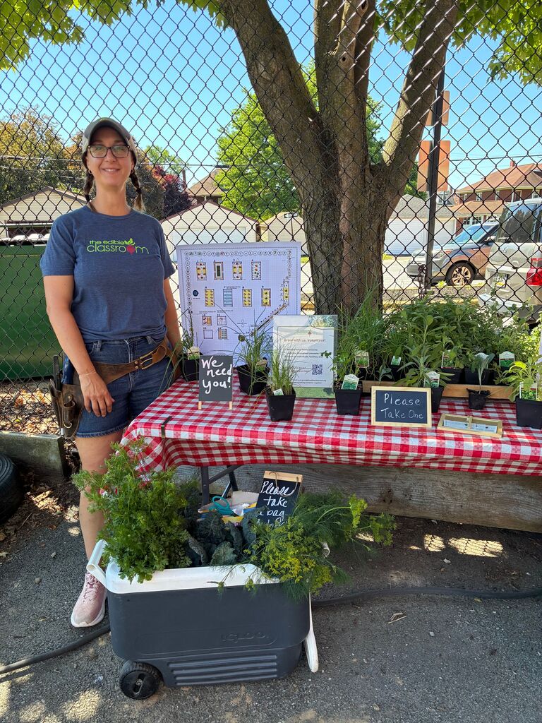 woman standing at a table with plants smiling