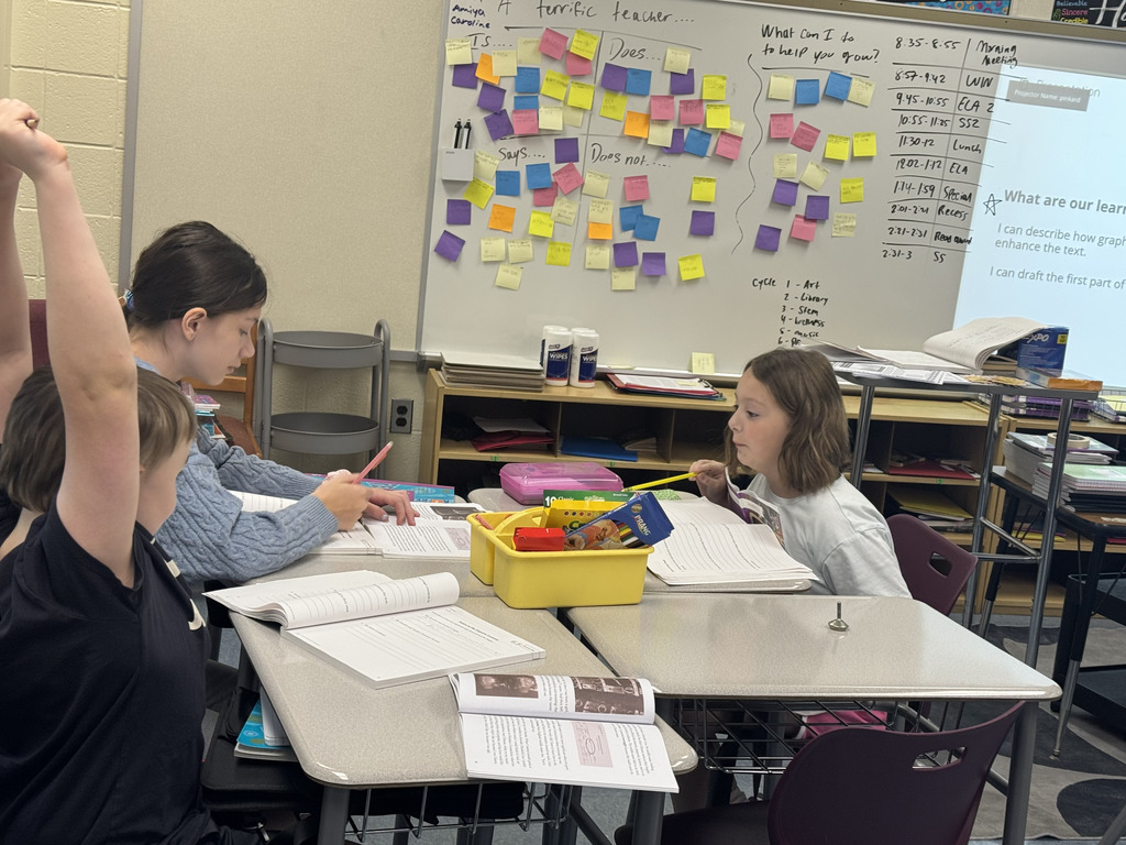 students sitting at tables working on their books