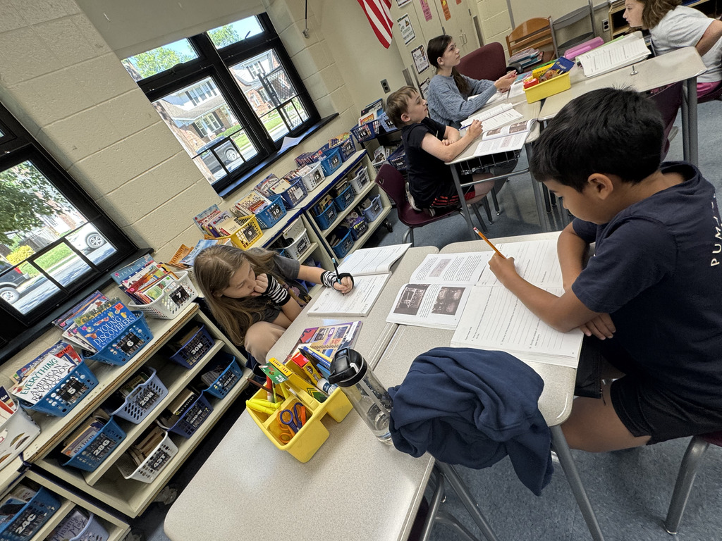 students sitting at tables working on their books