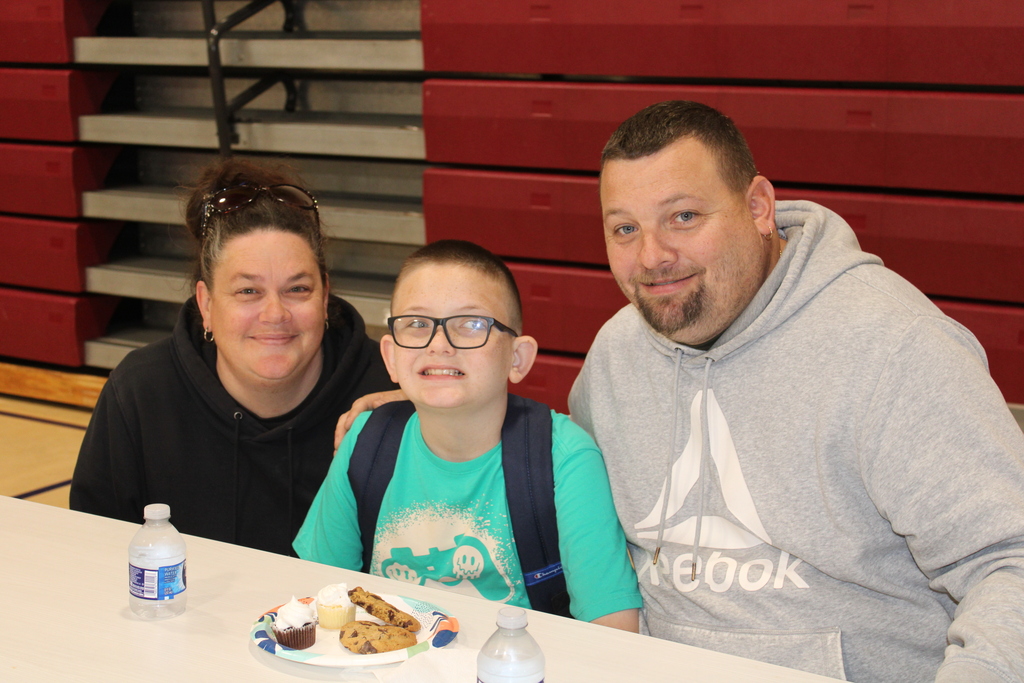 parents and student  smiling with food in front of them