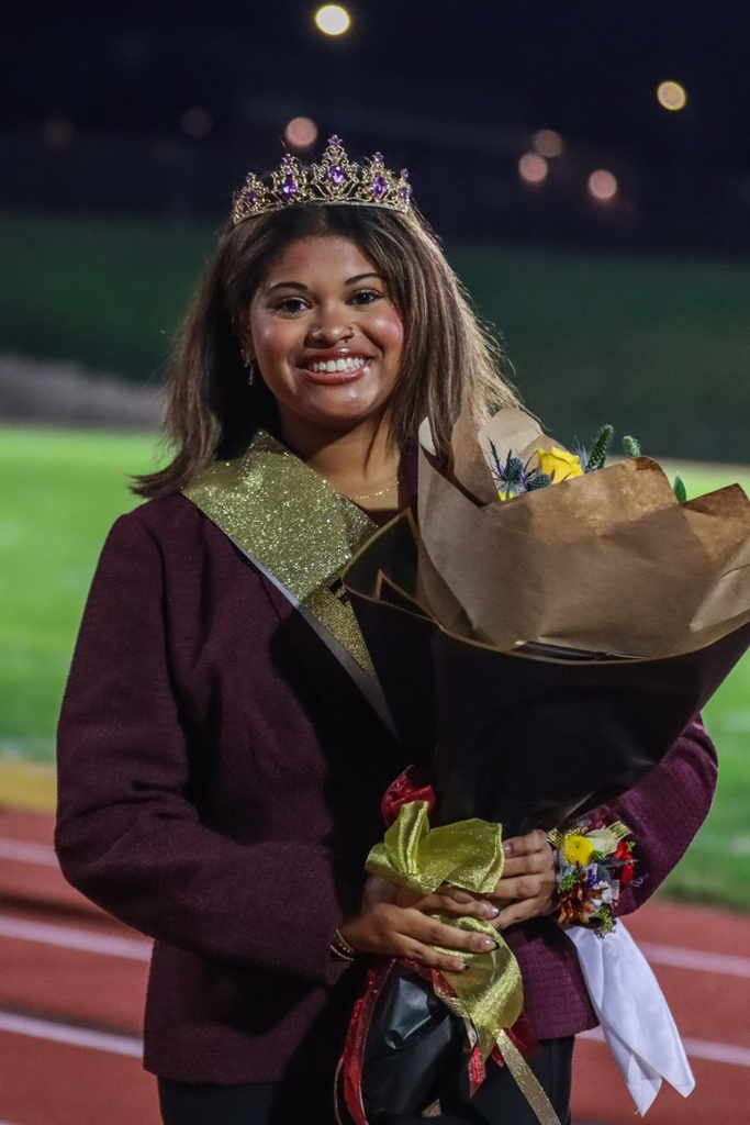 A smiling Columbia High School student is standing on the track after being crowned homecoming queen  