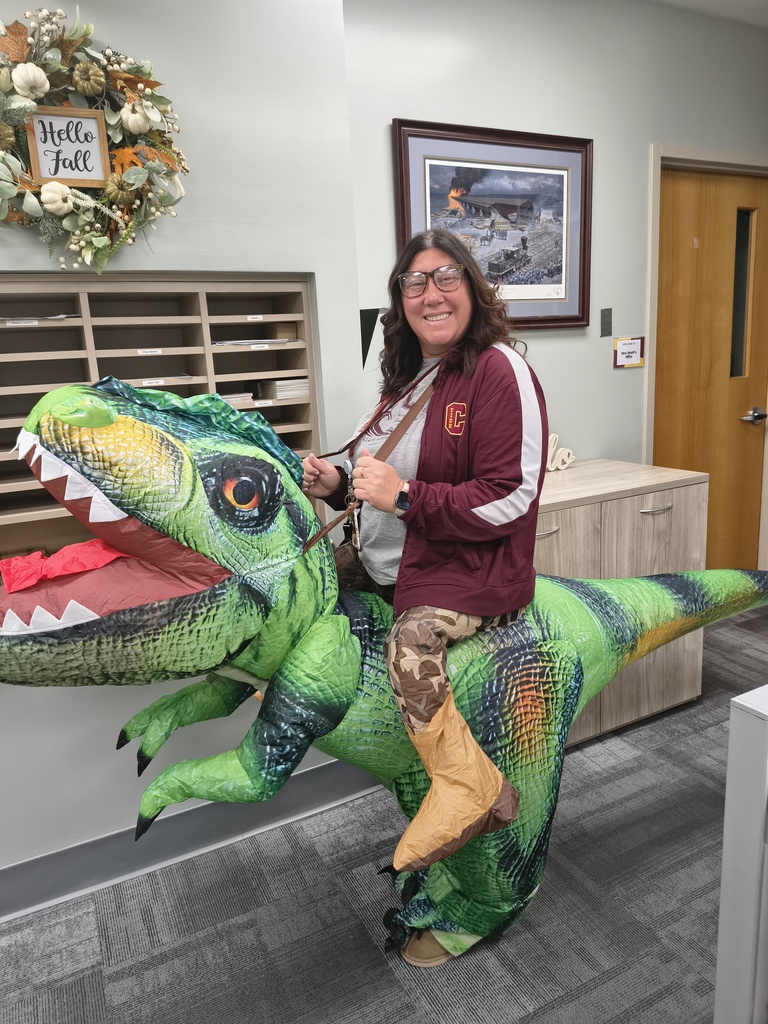 staff member posing in a dinosaur costume