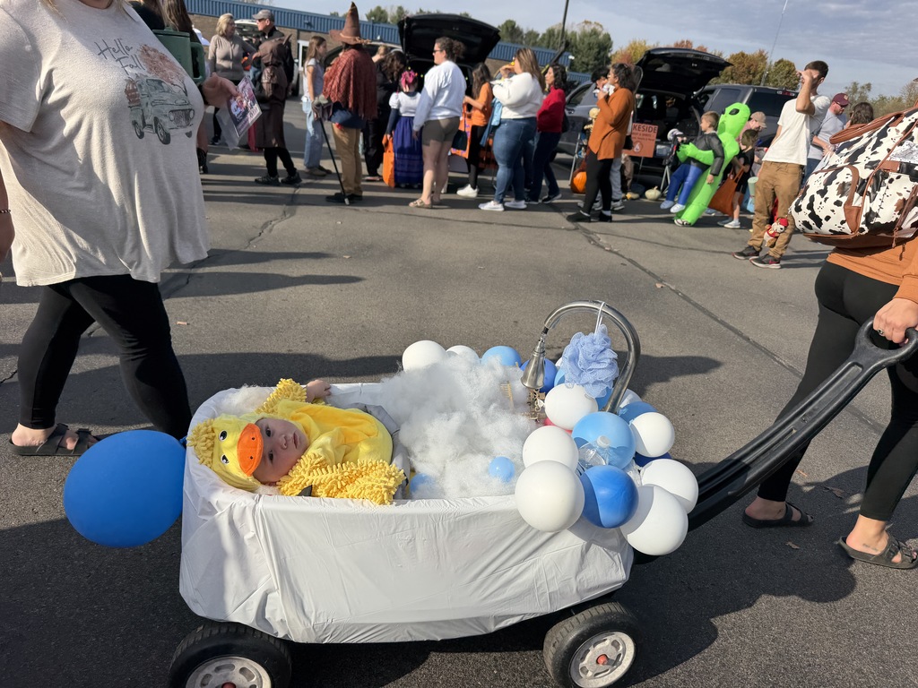 A baby dressed as a duck in bubble bath decorated wagon