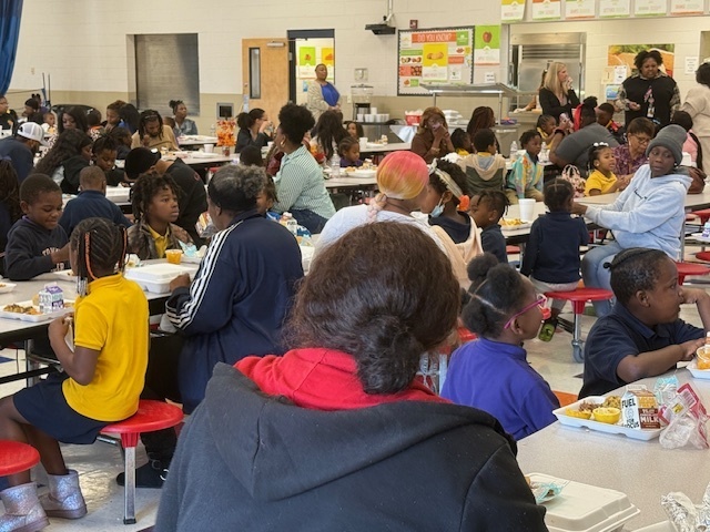 Parents enjoy a Thanksgiving lunch with their child at Stokes-Beard Elementary