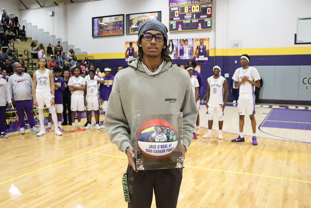 Jace O'Neal receives a basketball celebrating his 1,000 points scored while a player at Columbus High.
