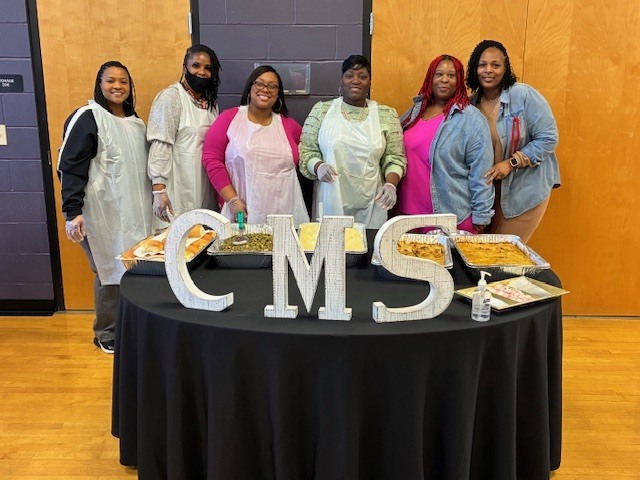 CMS staff serve the basketball team a celebratory dinner.