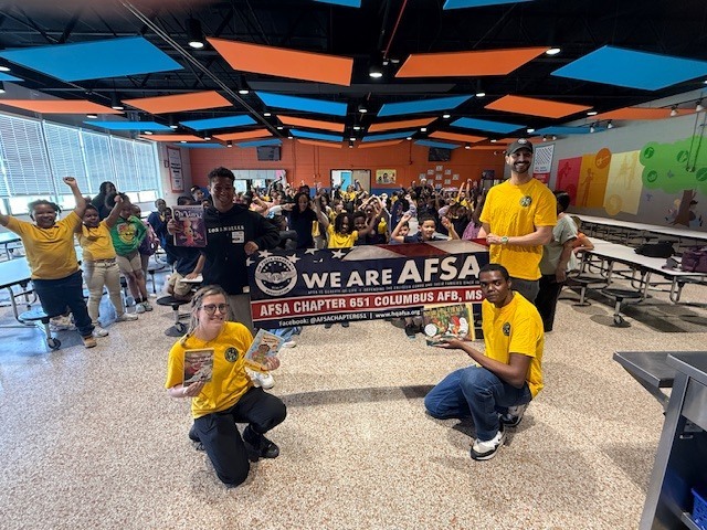 Members of the Air Force Sergeants Association Chapter 651 pose with Cook Elementary students. 