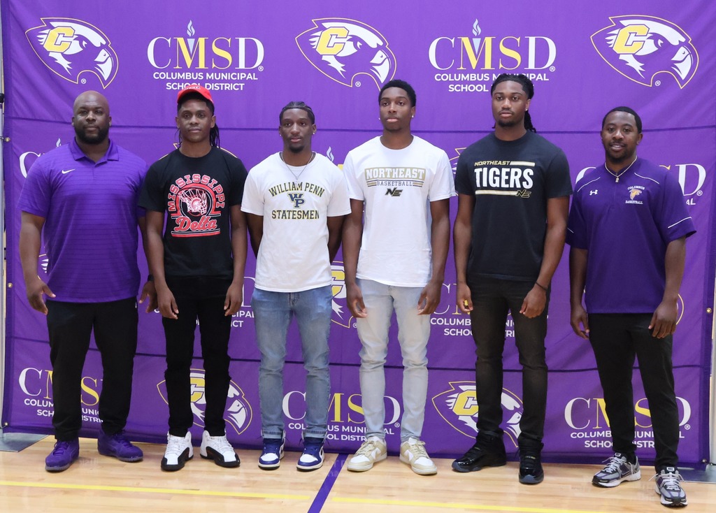 Coach Phillip Morris and Coach Javontae McDavid stands with the members of the CHS boys basketball team that signed to play college basketball.