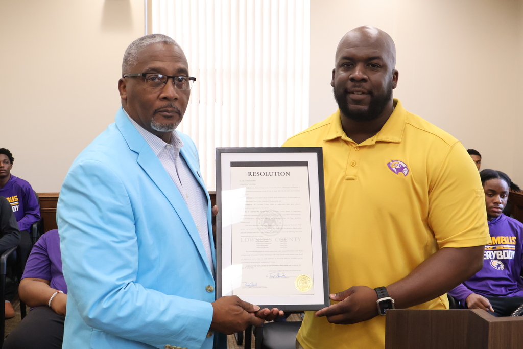 Lowndes County Supervisor Jeff Smith presents CHS Basketball Coach Phillip Morris with a resolution honoring his team's 5A State Championship. 