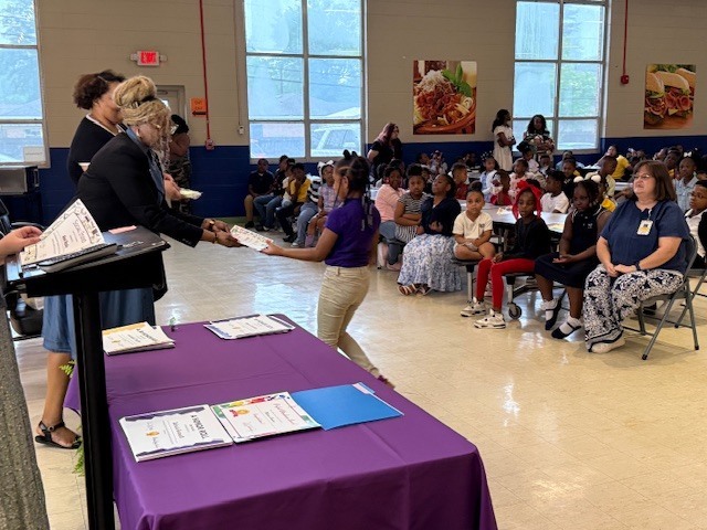 A student receives an award at Sale Elementary's  awards day. 
