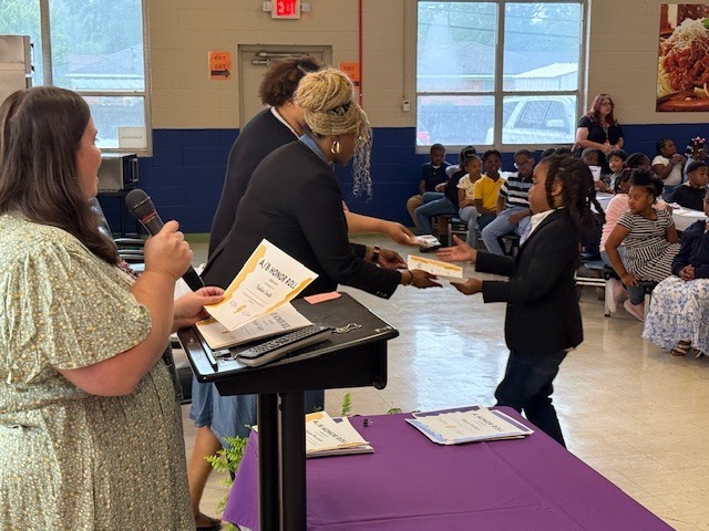 A student receives an award at Sale Elementary's  awards day. 