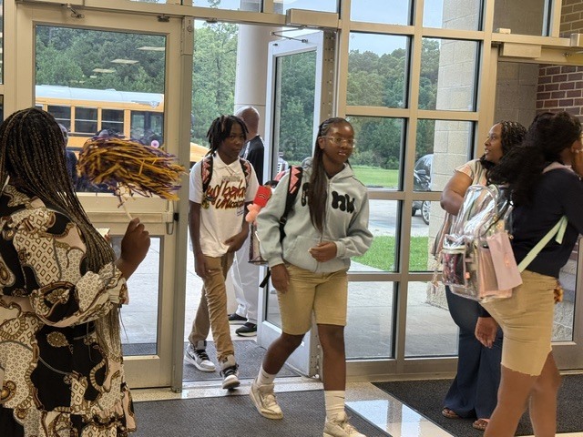 Columbus Middle School students get off the bus and walk into the building. 