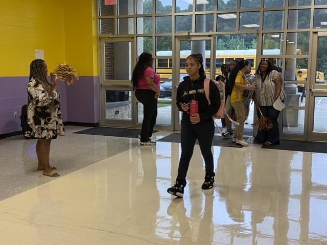 Columbus Middle School students get off the bus and walk into the building. 