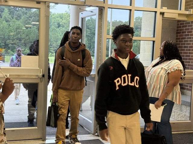 Columbus Middle School students get off the bus and walk into the building. 