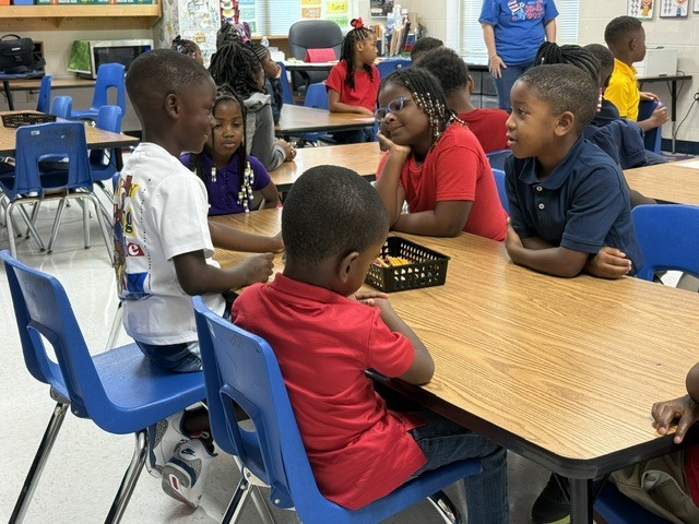 Stokes-Beard Elementary students talk to each other at a table. 