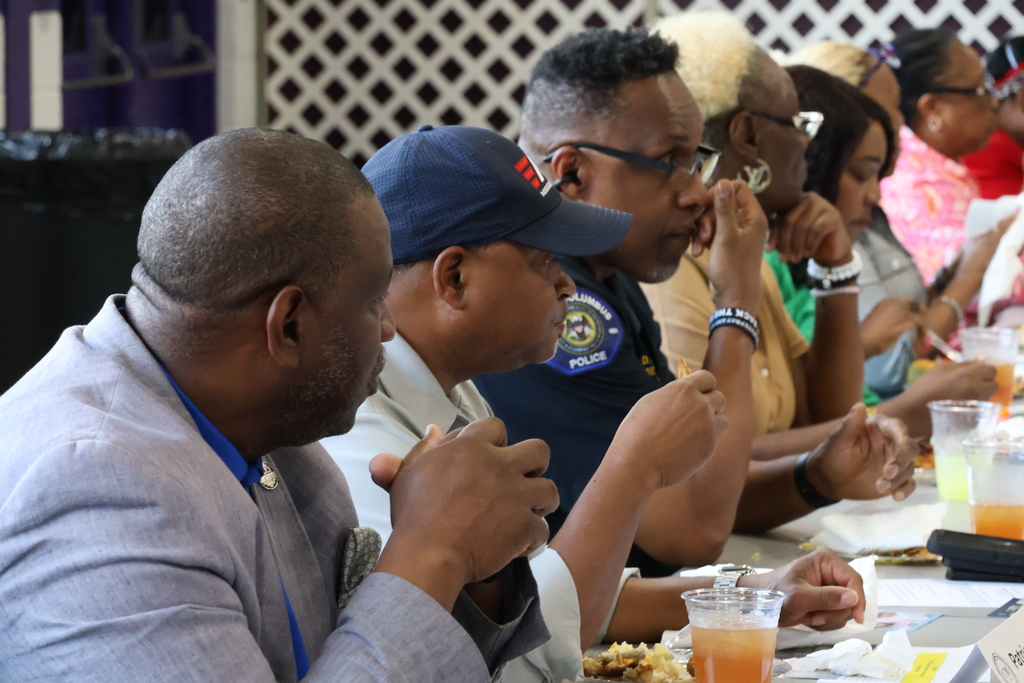Attendees at the Superintendent's Roundtable sit at a table to listen to a presentation and enjoy lunch.
