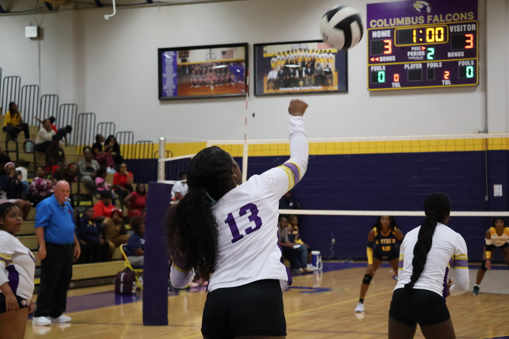 Columbus High volleyball player serves the ball during a game. 