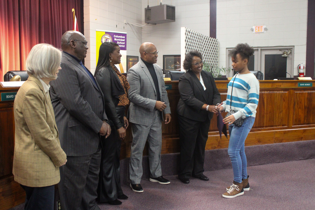 Board member shakes students hand