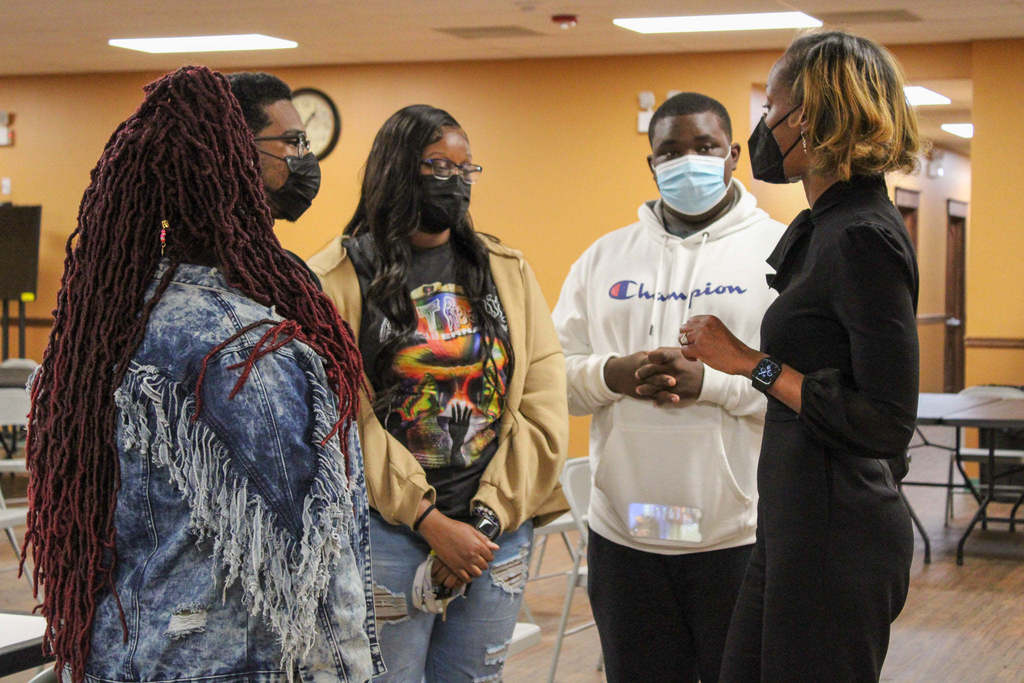 Dr. Labat speaking to a group of students during a community meeting.