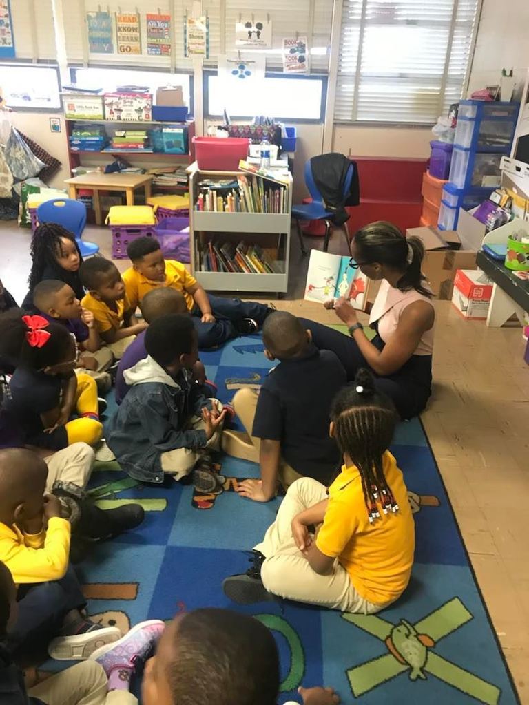 Dr. Labat reading to a group of students