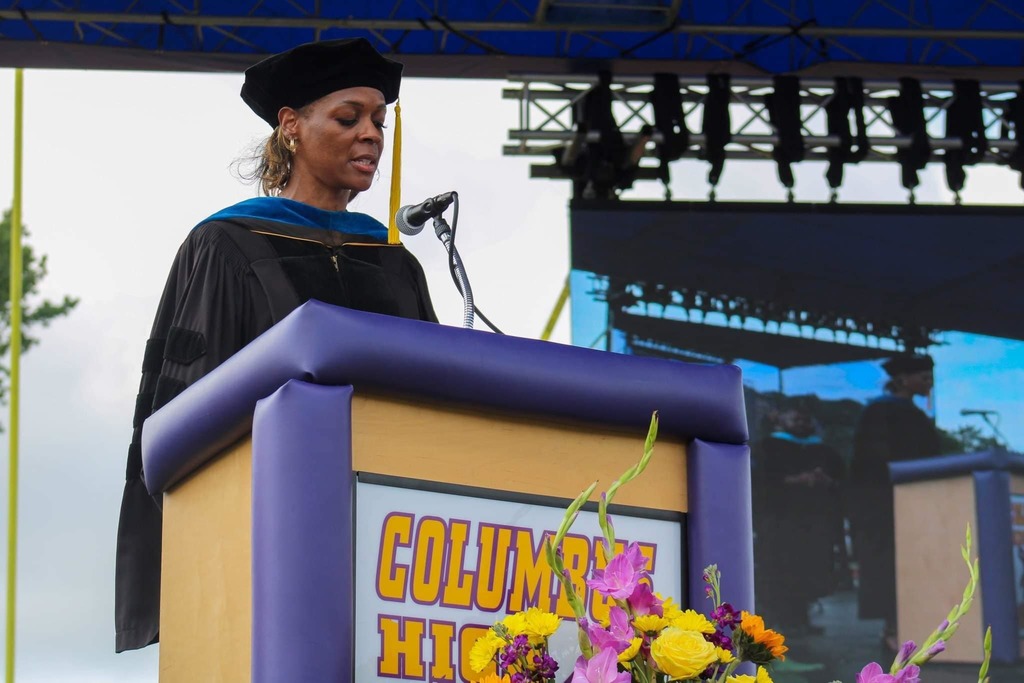 Dr. Labat stands at the podium at the CHS graduation of 2022
